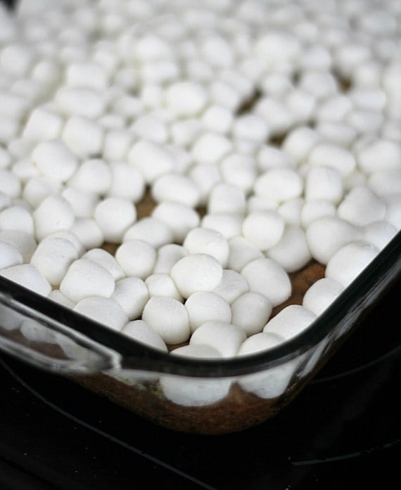 Mini marshmallows over a cookie base in a baking pan