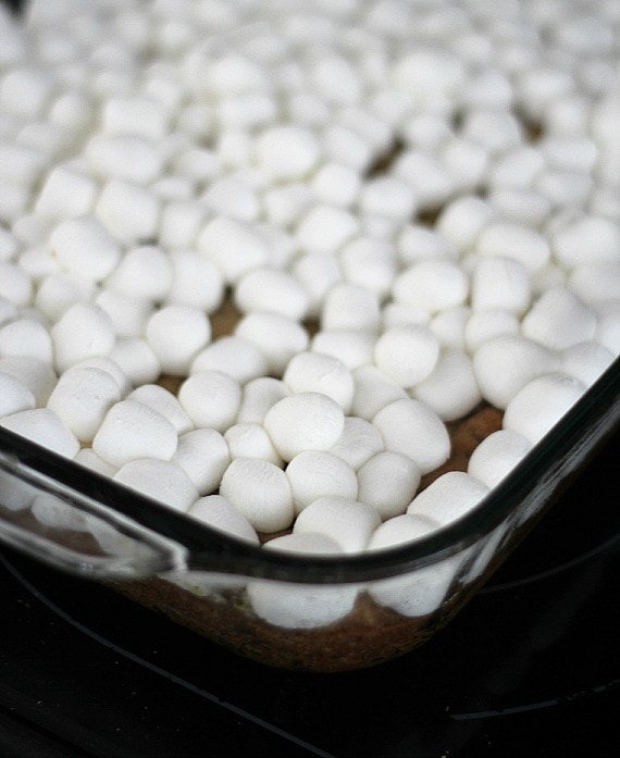 Mini marshmallows over a cookie base in a baking pan