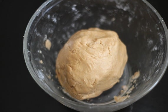 A ball of peanut butter dough in a mixing bowl