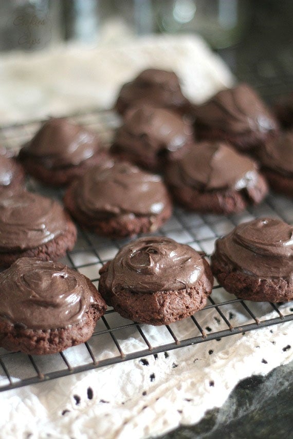 Chocolate-frosted buckeye brownie cookies on a black wire rack.