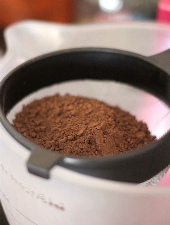 Cocoa powder in a sifter on the edge of a mixing bowl