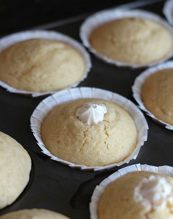 Cream-filled vanilla muffins in a muffin tin