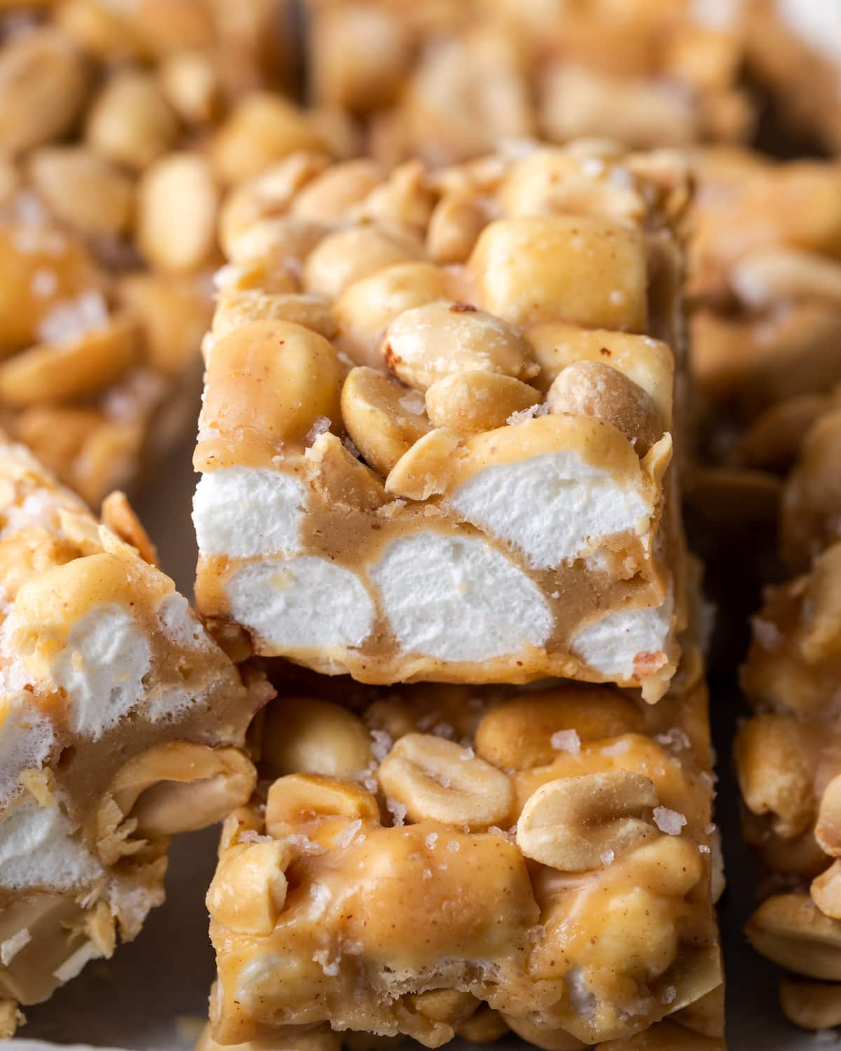Close up of a homemade PayDay bar with a peanut and marshmallow center, sitting on top of the other bars.
