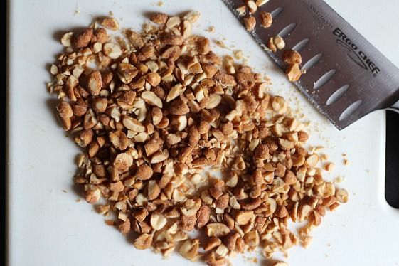 Chopped honey roasted peanuts on a cutting board