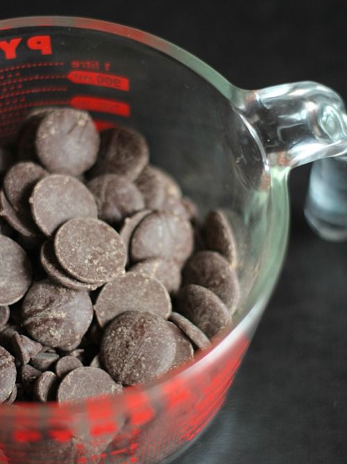 Chocolate melting wafers in a large glass measuring cup