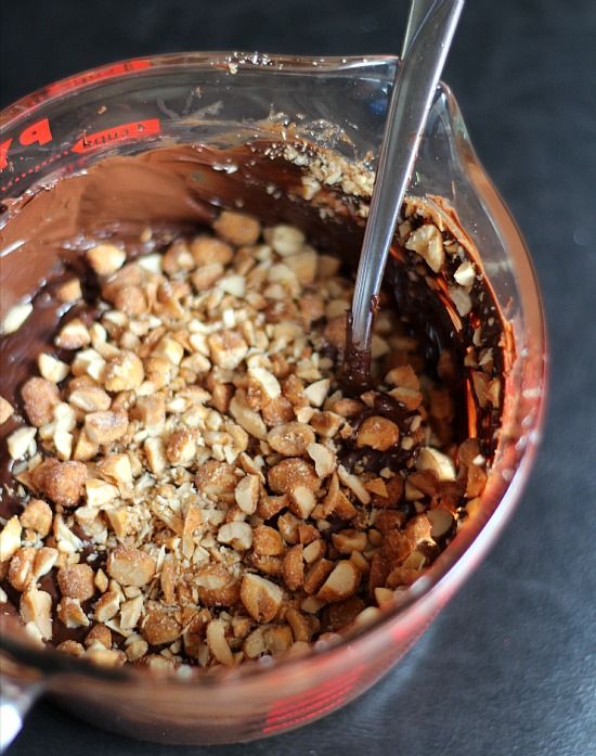 Melted chocolate with chopped peanuts in a glass measuring cup