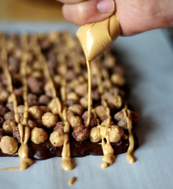 Peanut butter being drizzled over chocolate peanut butter bars