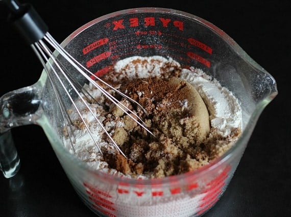 Top view of dry ingredients and a whisk in a large liquid measuring cup