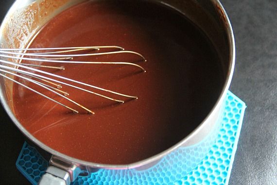 Top view of melted chocolate and butter in a saucepan with a whisk