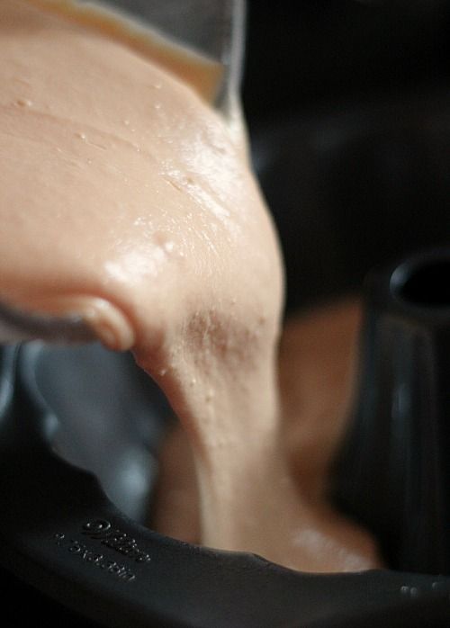 Orange cake batter being poured into a bundt pan