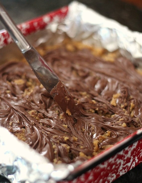 Nutella being swirled into blondie batter in a baking pan