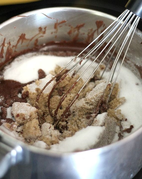 Brown sugar, white sugar, and chocolate in a mixing bowl with a whisk