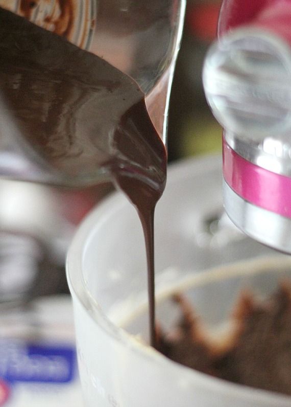 Chocolate cake batter being poured into a cake pan