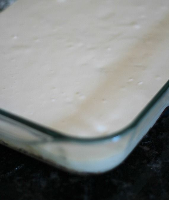 Lemon cream cheese mixture over shortbread crust in a 9x13 baking dish