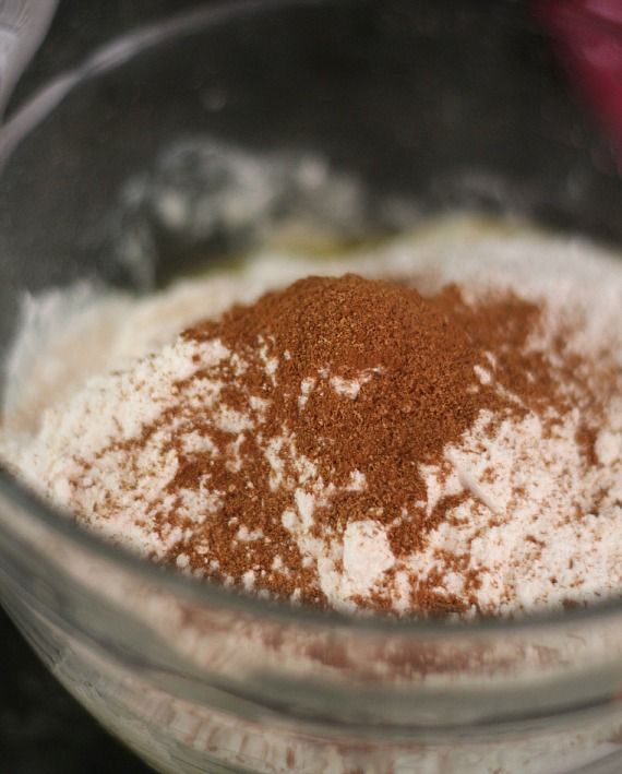Ground cinnamon on top of dry ingredients in a mixing bowl