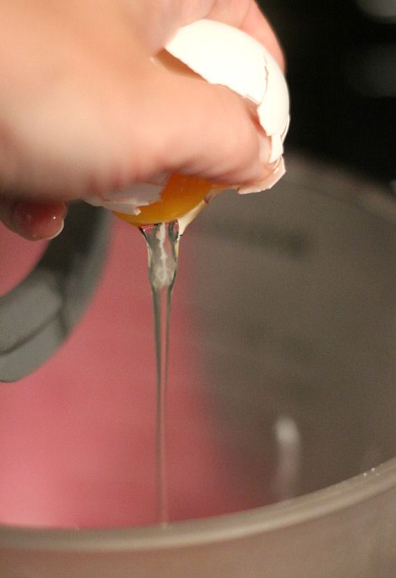 An egg being cracked into a mixing bowl