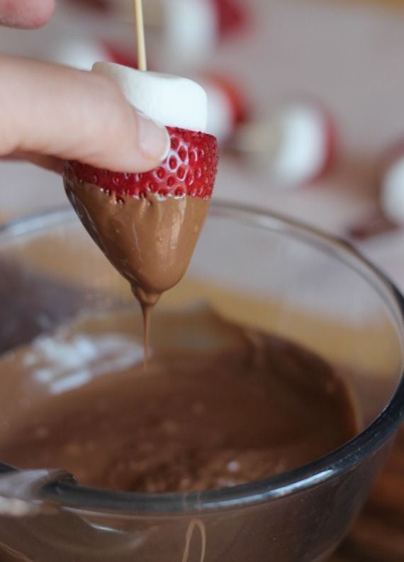 Strawberry and marshmallow on a skewer dipped in melted chocolate