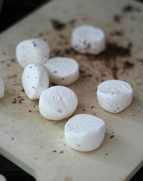 Halved marshmallows on a cutting board