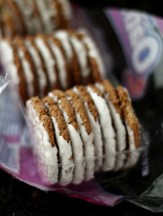 Frosted oatmeal cookies in a plastic tray