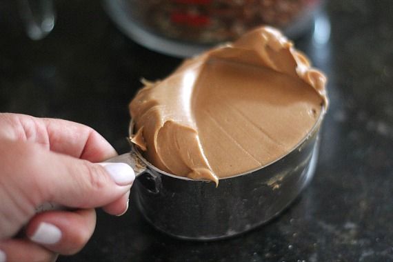 A measuring cup of peanut butter