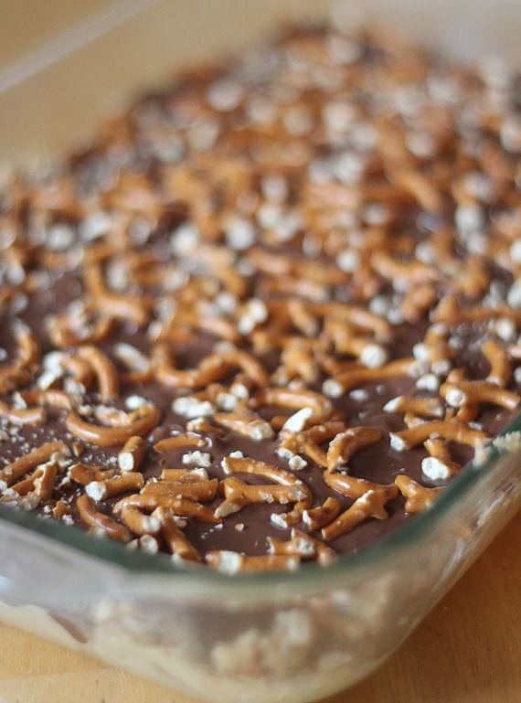 A pan of no-bake chocolate peanut butter bars topped with pretzel pieces
