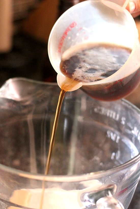 A liquid measuring cup of Root beer being poured into a mixing bowl