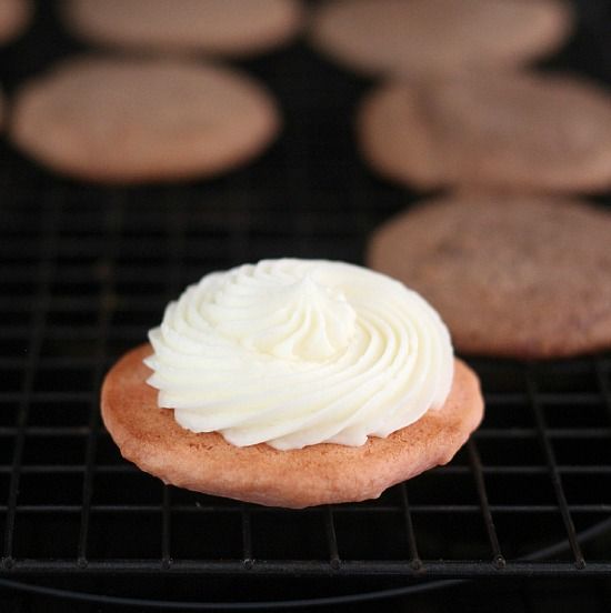 A swirl of vanilla frosting on a strawberry cookie