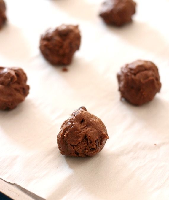 Chocolate cookie dough balls on a parchment-lined baking sheet