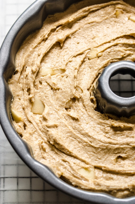 Close up of a bundt pan filled with apple cake batter.