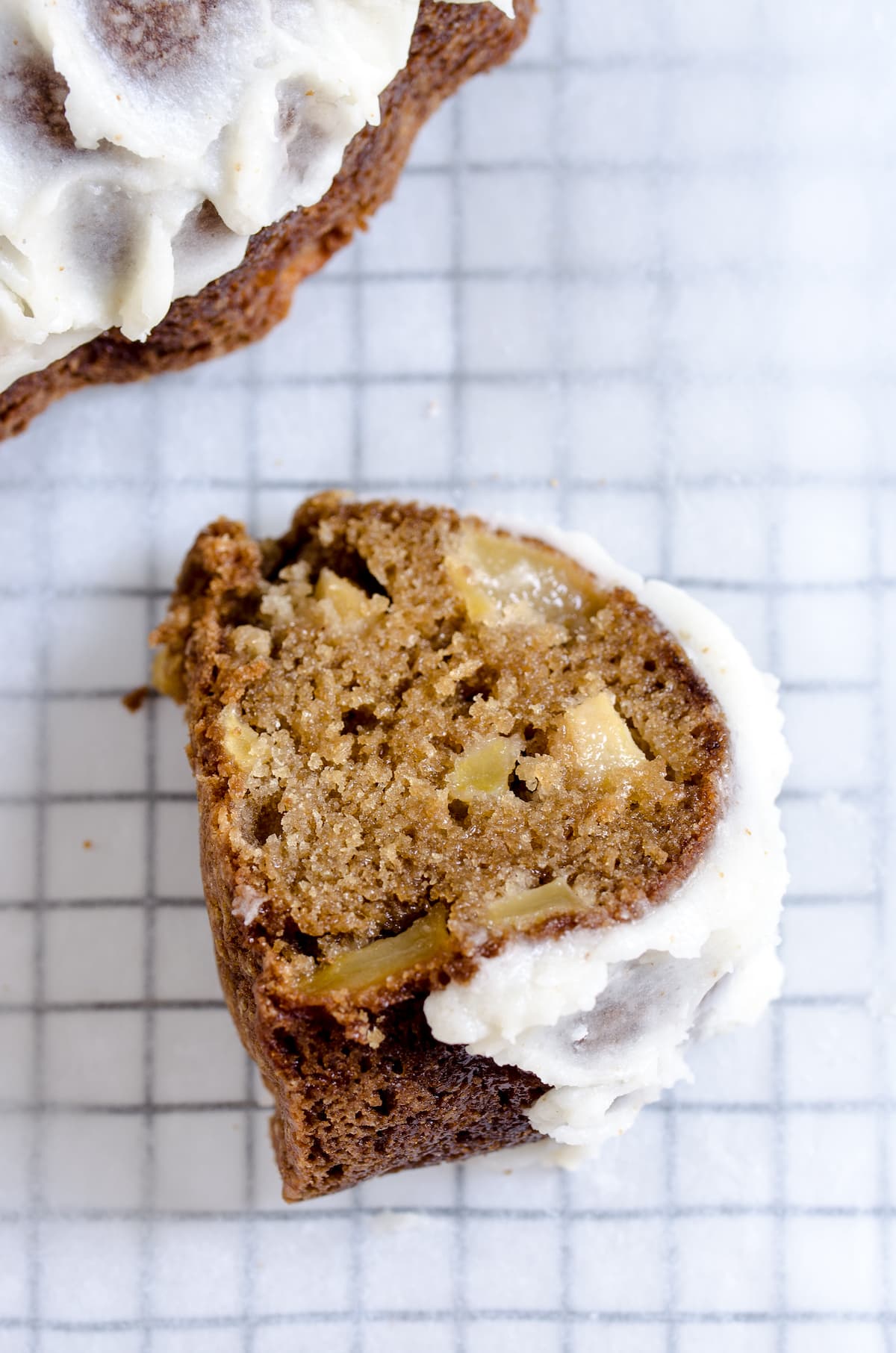 A slice of frosted bundt cake on a cooling rack