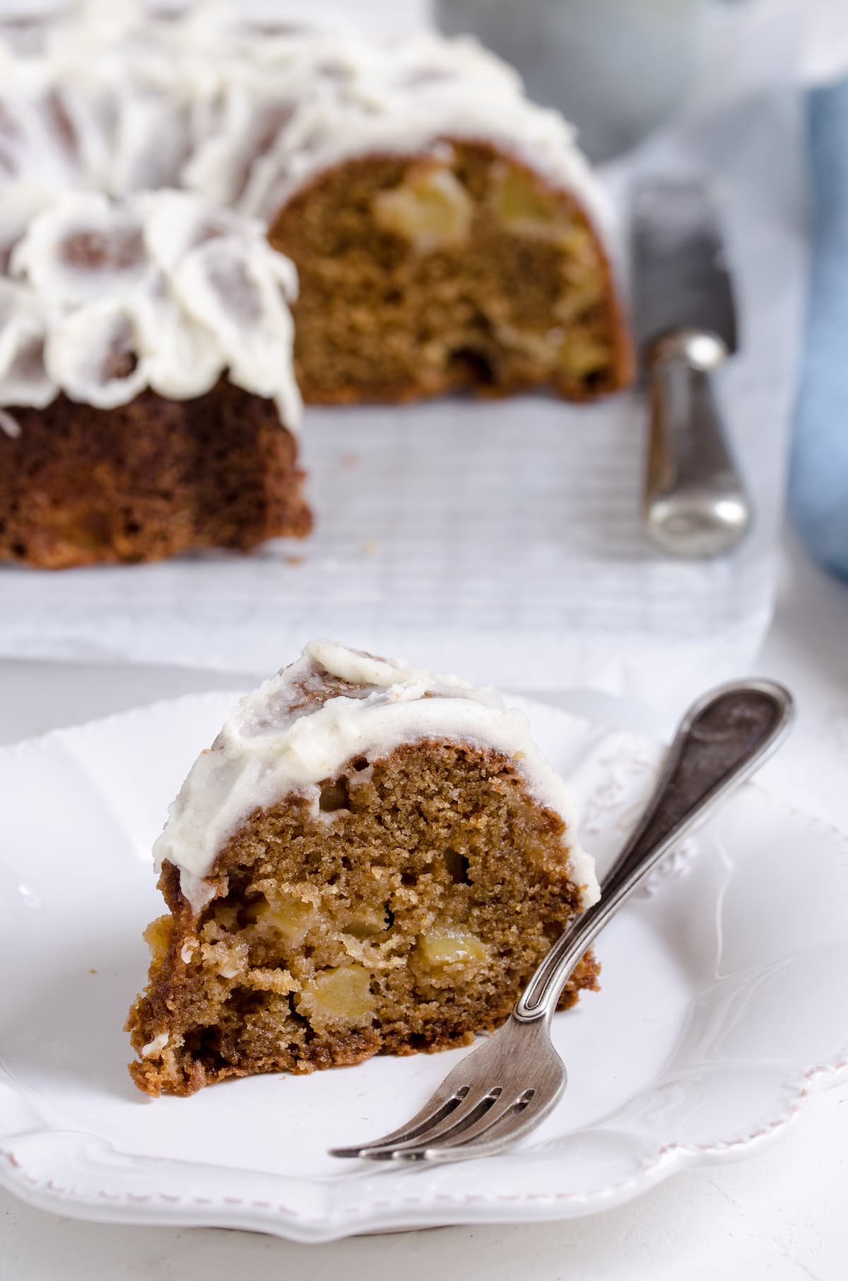 A slice of bundt cake on a white plate with a fork