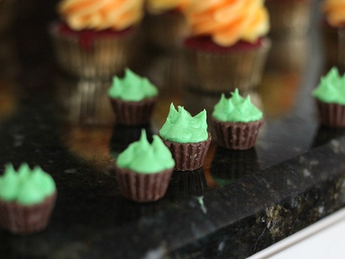 Miniature peanut butter cups topped with green frosting