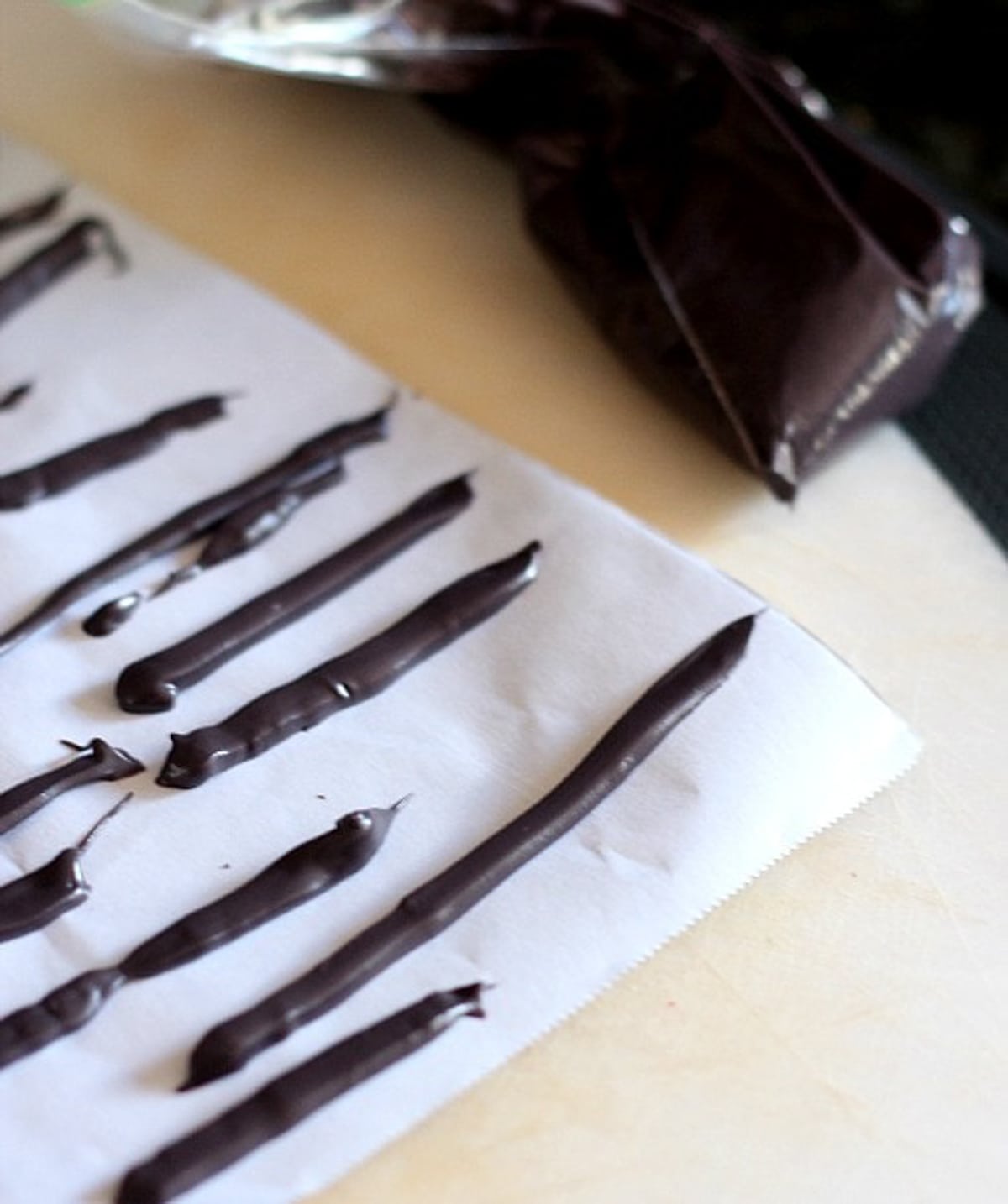 Lines of melted chocolate piped onto parchment paper