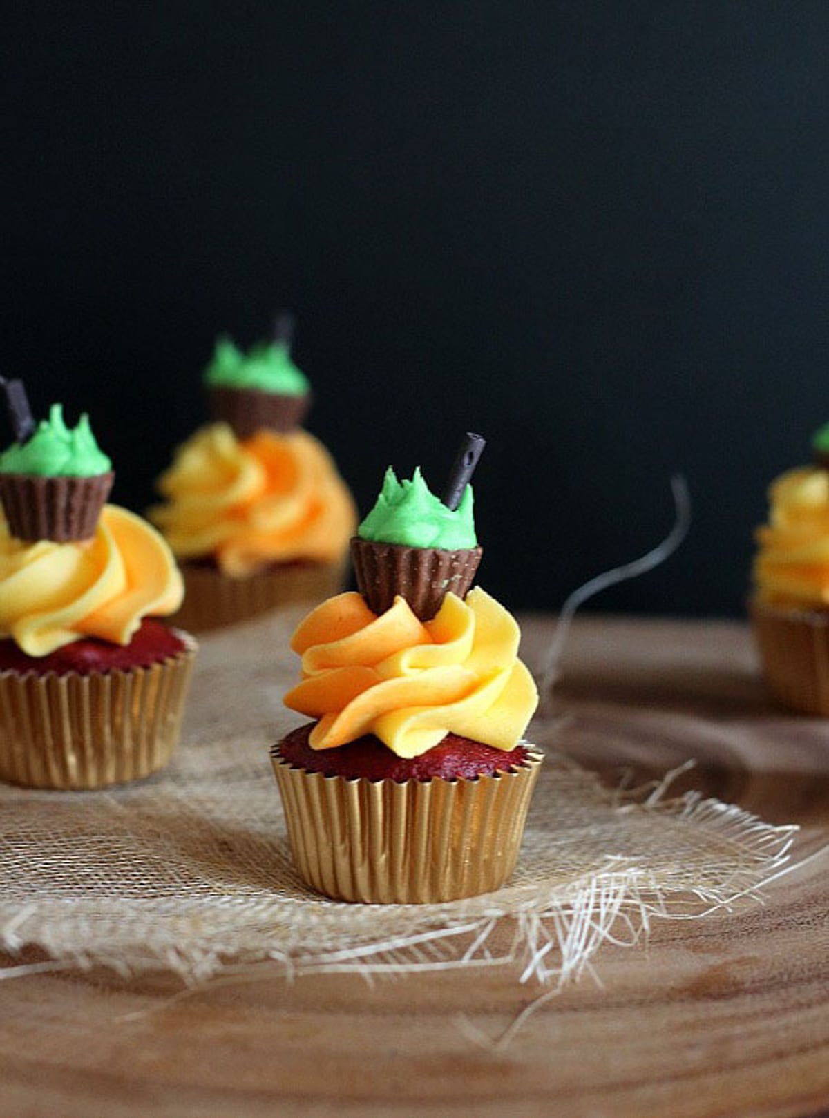 A red velvet cupcake topped with frosting to look like fire and a peanut butter cup cauldron