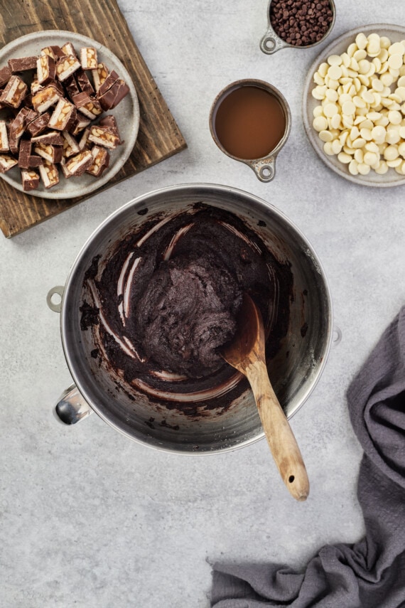The batter for Snickers brownies comes together in a mixing bowl.