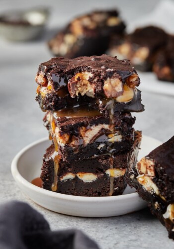A stack of gooey chocolatey Holy Heck Snickers brownies.