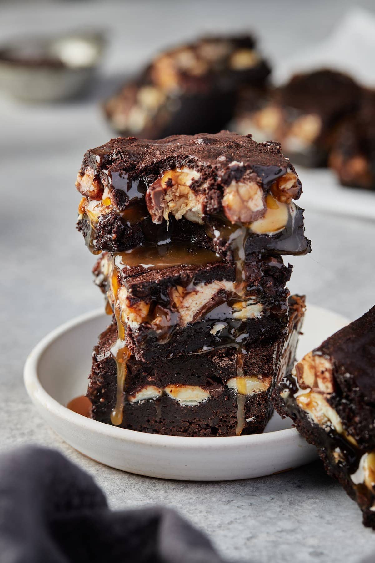 A stack of gooey chocolatey Holy Heck Snickers brownies.