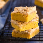 Stack of 3 slices of pumpkin coffee cake on a cooling rack