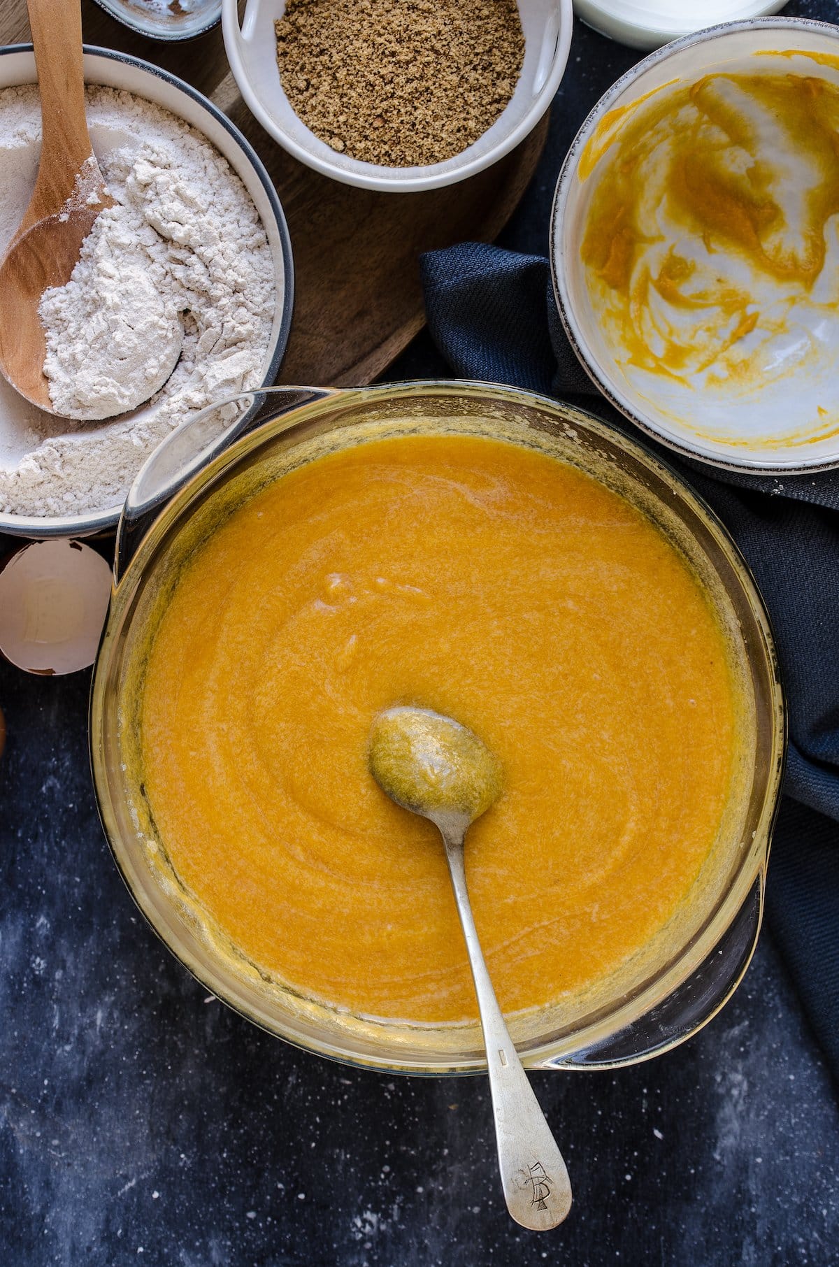 Glass bowl with pumpkin cake batter and a spoon