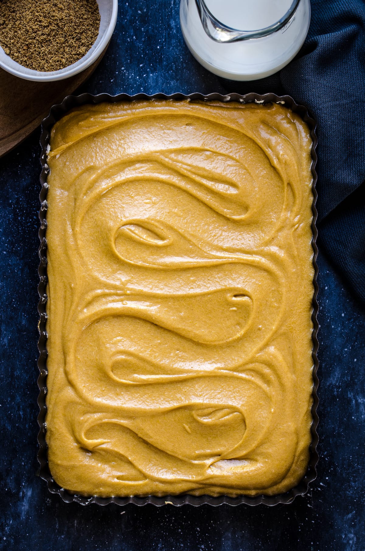 Pumpkin cake batter in a glass baking dish