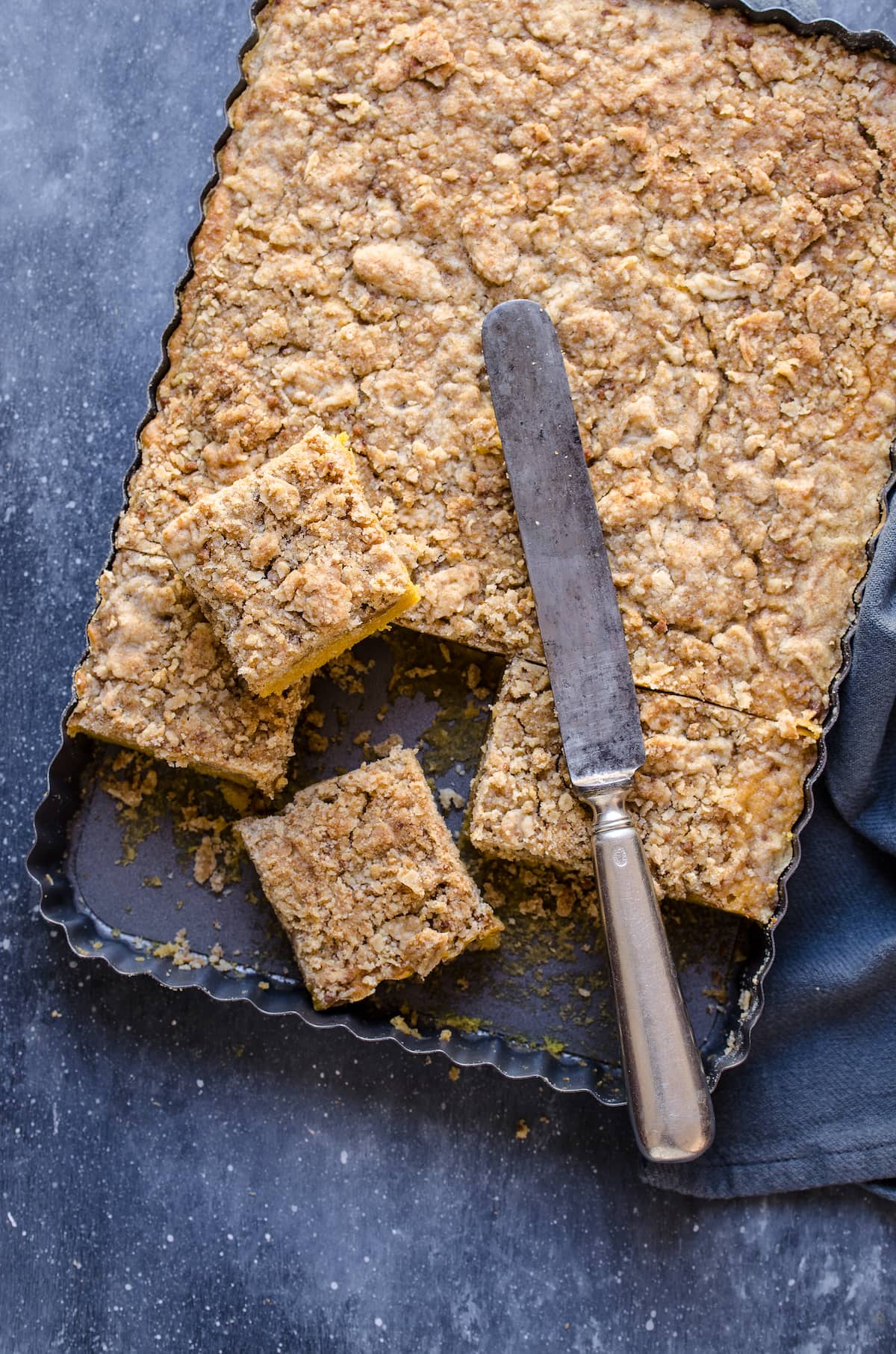 Baked pumpkin cake on a cooling rack with a knife and slices taken out