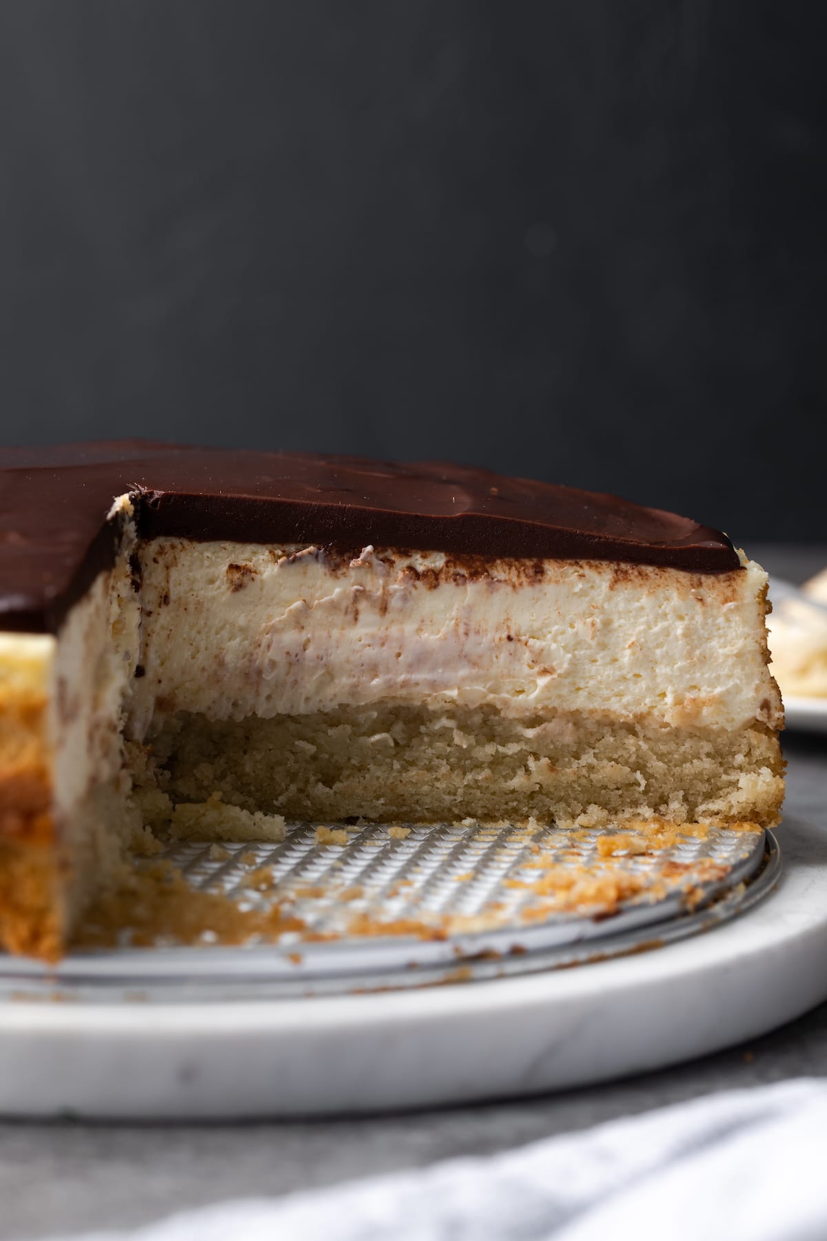 Boston Cream Pie cheesecake with slices missing to reveal the cake layers.