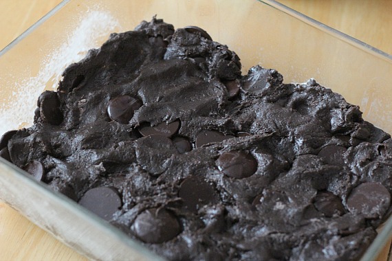 Cake mix brownie batter pressed into a clear baking pan.