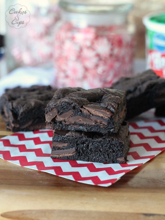 Two cake mix brownies stacked on top of one another, with more brownies in the background.