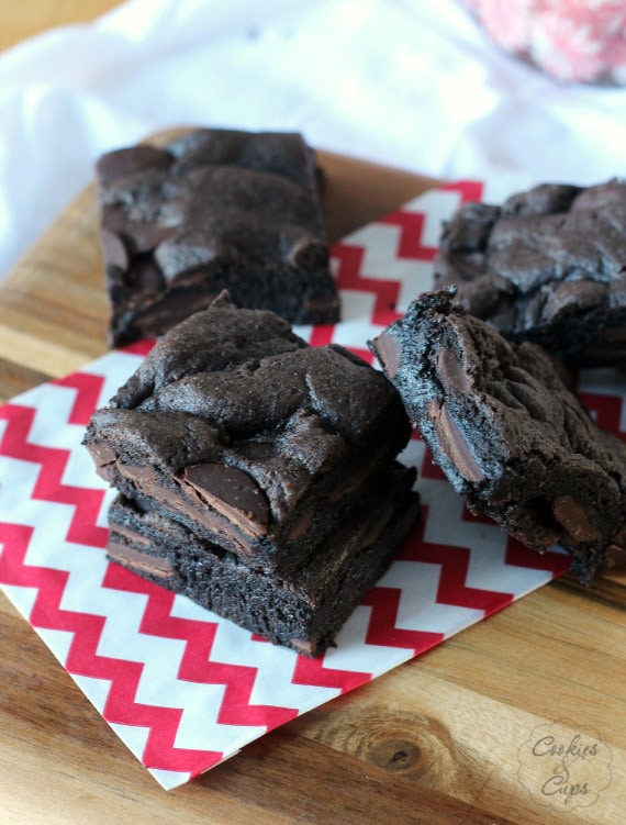 Stacks of chocolate cake mix brownies on a red and white patterned napkin.