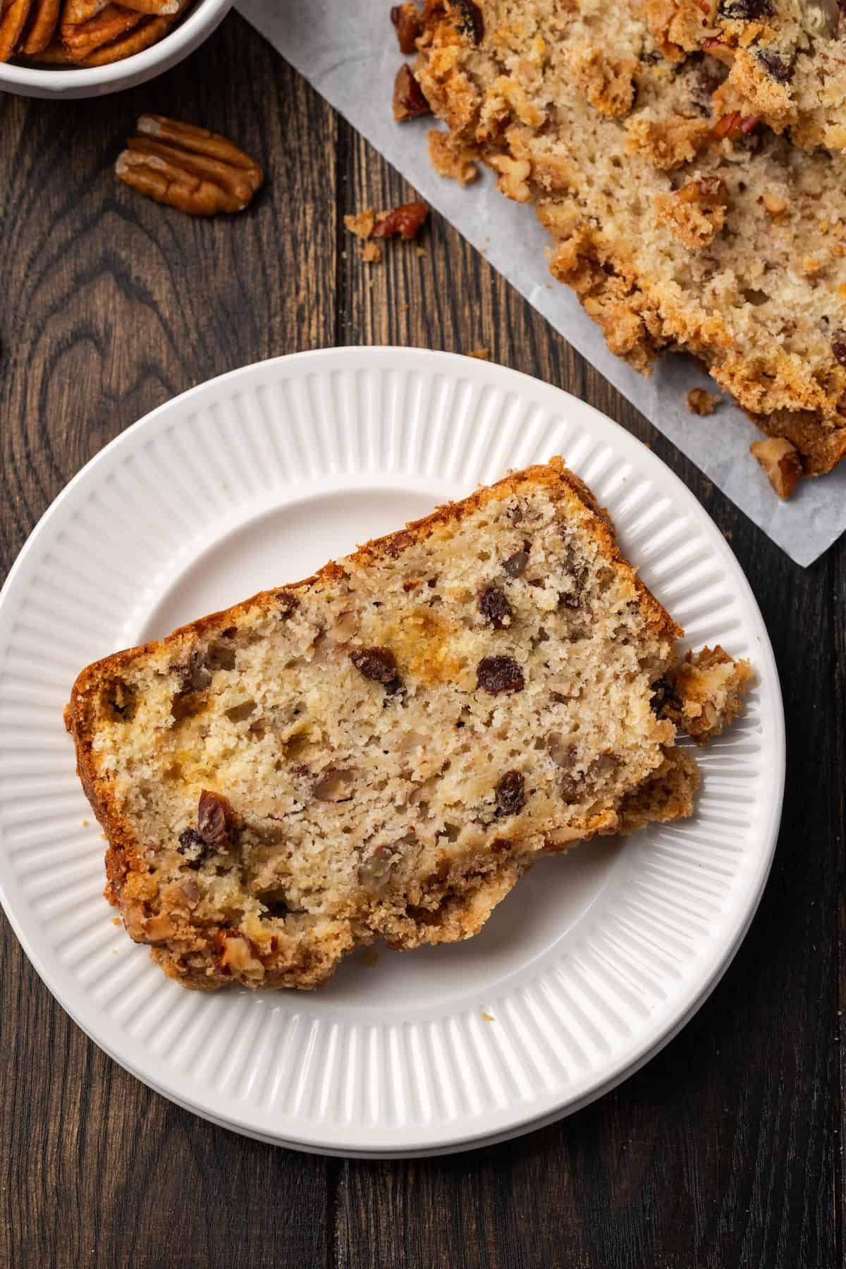 Overhead view of a slice of apple pie bread on a white plate.