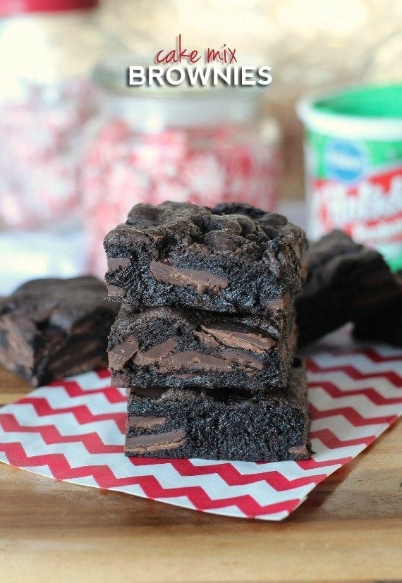 A stack of three cake mix brownies with more brownies in the background.