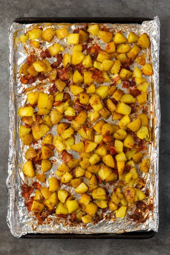 Ranch potatoes and bacon on a lined baking sheet after roasting.