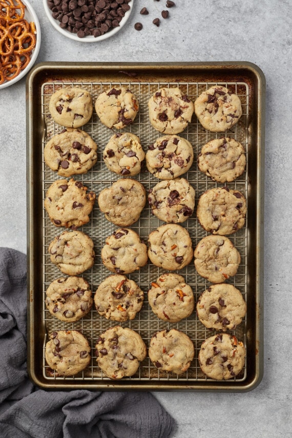 Baked salty pretzel chocolate chip cookies on a lined baking sheet.