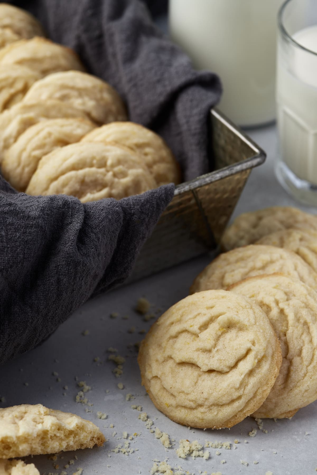 Amish sugar cookies in a basket, with more cookies scattered around.